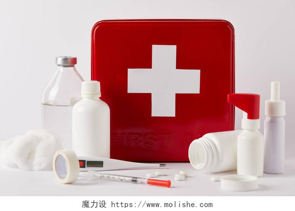 白色背景下的医用品特写镜头的红色急救箱与各种医疗瓶和供应白色